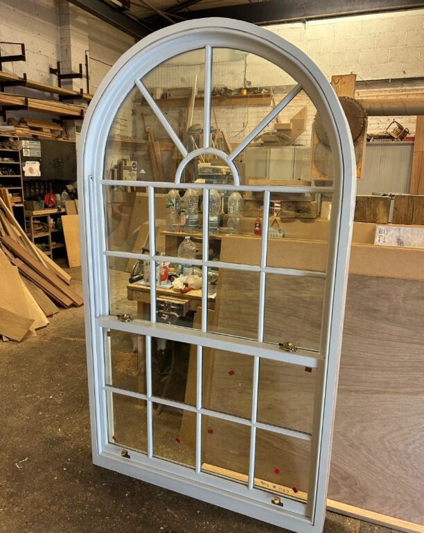 Large arched window with fanlight and glazing bars being manufactured in workshop