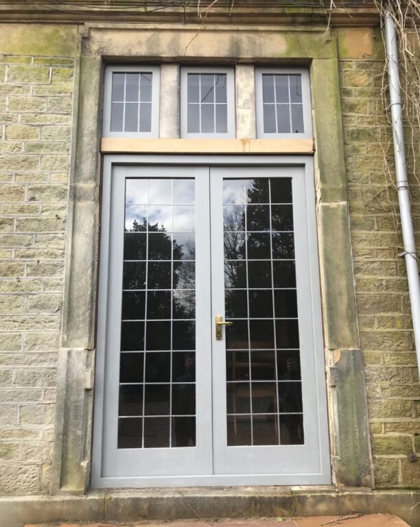 White French doors with fanlight and Georgian glazing bars in traditional stone building