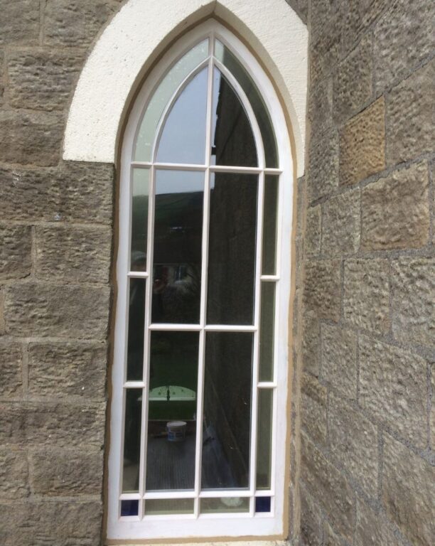 Gothic arched window with traditional glazing bars in stone church or period building