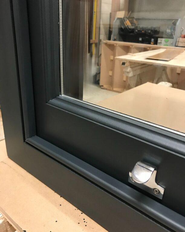 Close-up detail of traditional sash window hardware showing catch mechanism and frame construction