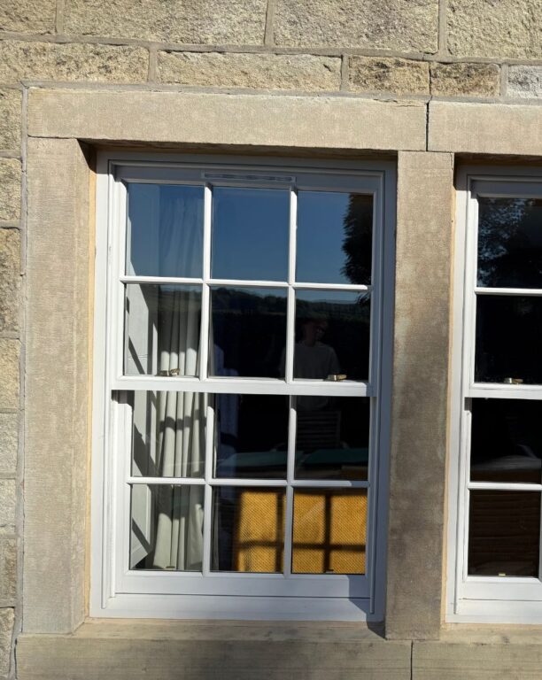 Georgian style sash window with white glazing bars and stone surround in period building