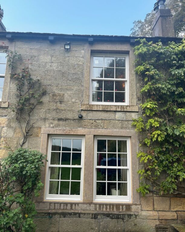 Traditional Georgian sash windows with glazing bars in period stone cottage