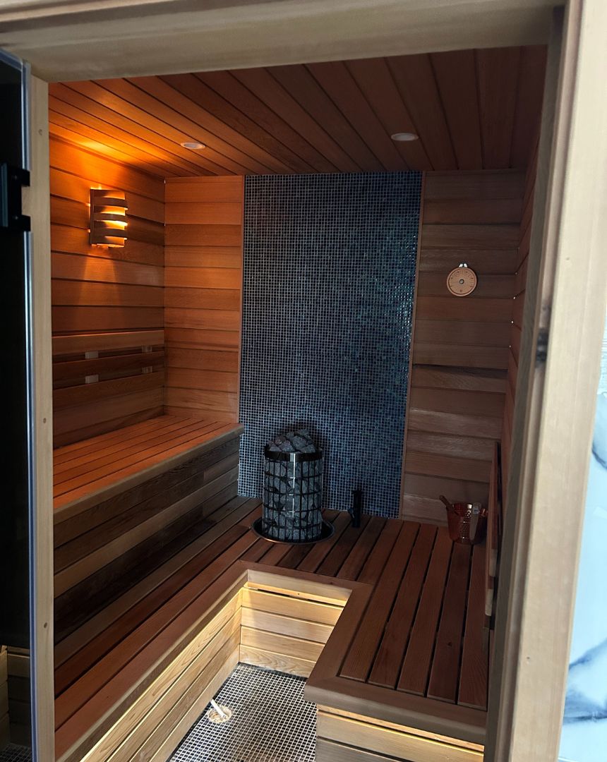 Custom built sauna interior with cedar wood benching and blue mosaic tile feature wall