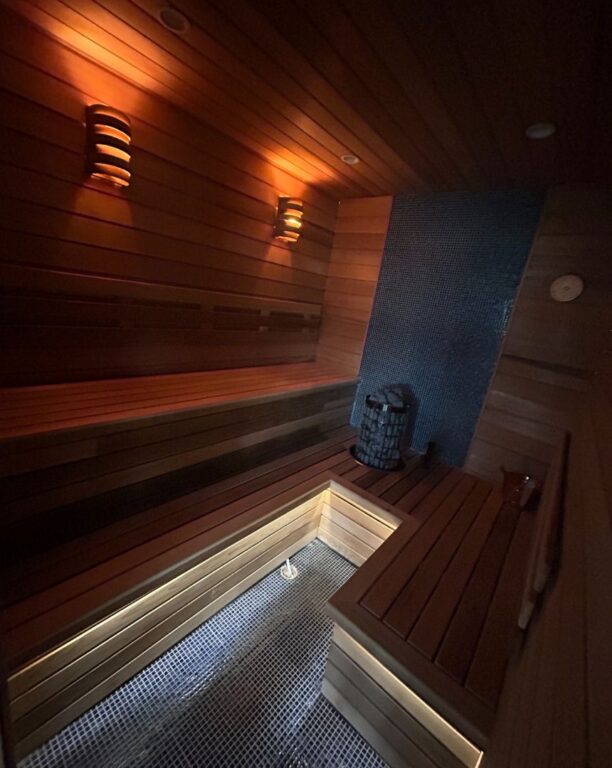Atmospheric evening view of custom sauna interior with cedar benches and ambient lighting
